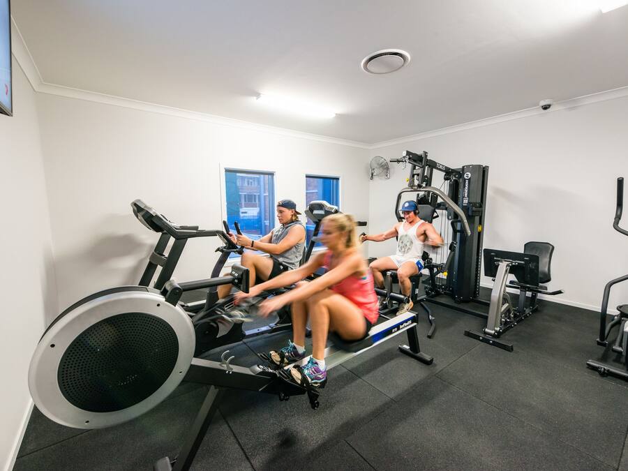 A gym with stationary bikes, weight machines, and a treadmill.