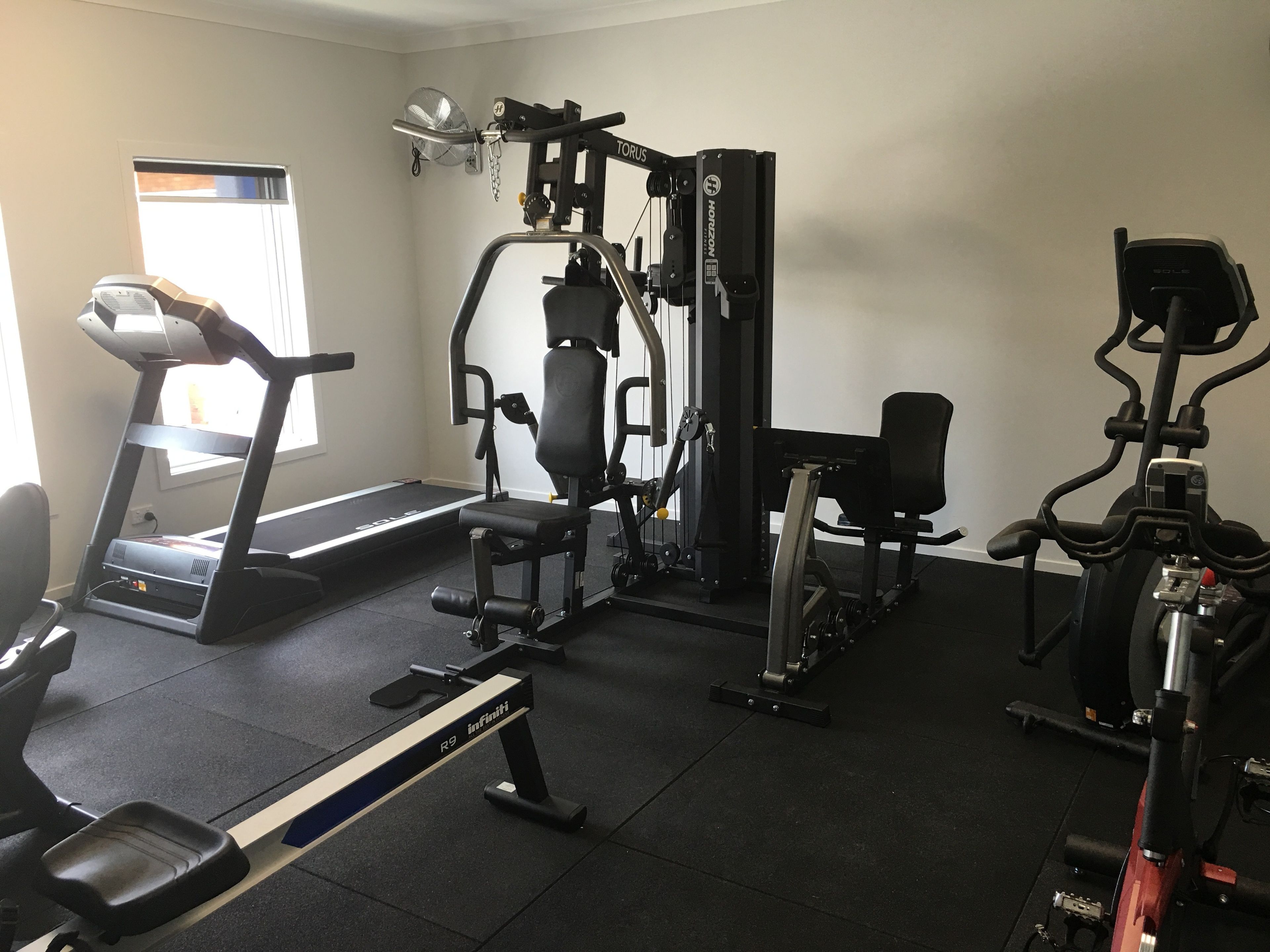 A gym with a treadmill, weight machines, and a stationary bike.