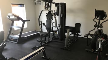 A gym with a treadmill, weight machines, and a stationary bike.