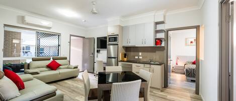 Un appartement moderne comprenant un salon, un coin repas, une cuisine et une chambre.