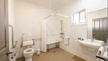 Ein Badezimmer mit Toilette, Dusche, Waschbecken und einem Fenster.