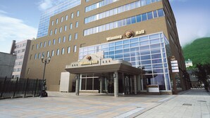 A modern building with a prominent glass entrance and a sign reading "Winding Hall". - Winning Hotel (Hakodate)