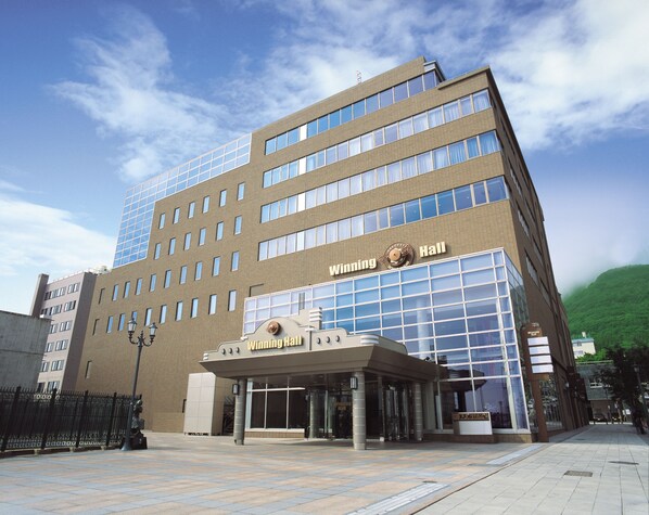 Un edificio moderno con una entrada de vidrio destacada y un letrero que dice 