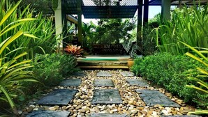 A stone pathway leading to a covered area with a bench. - Chomphu Resort Khaolak (Takua Pa)