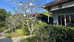 A residential building with a balcony, surrounded by lush greenery and a clear blue sky. - Chomphu Resort Khaolak (Takua Pa)