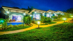 A row of modern, well-lit villas with a swimming pool and a landscaped garden. - Chomphu Resort Khaolak (Takua Pa)