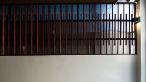 A room with a large window covered by vertical wooden slats. - KENCOZY accommodation (Bangkok)