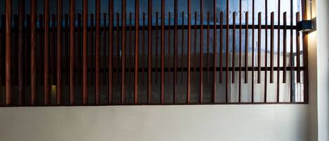 A room with a large window covered by vertical wooden slats.