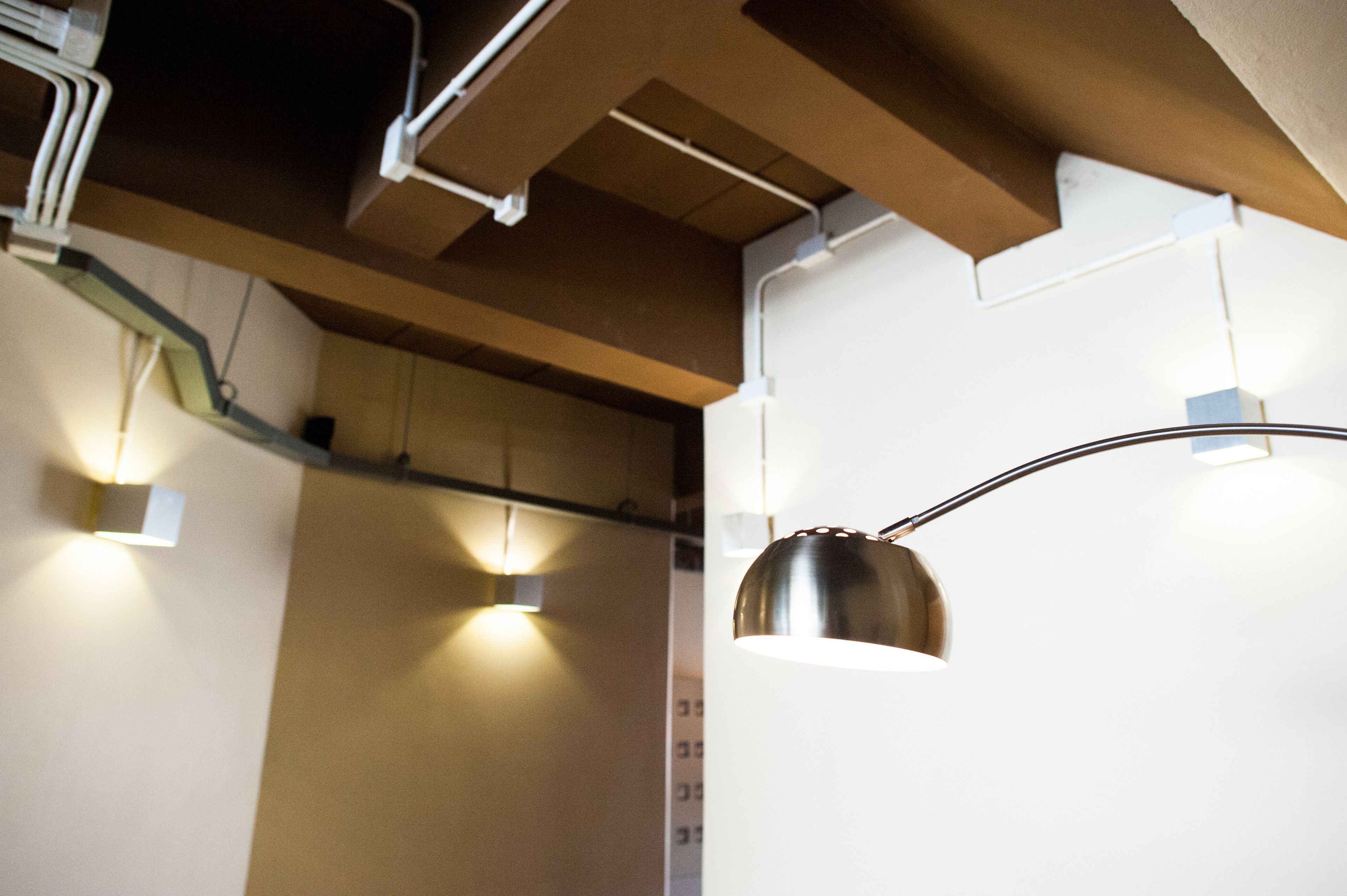 A ceiling with exposed ductwork and lighting fixtures.