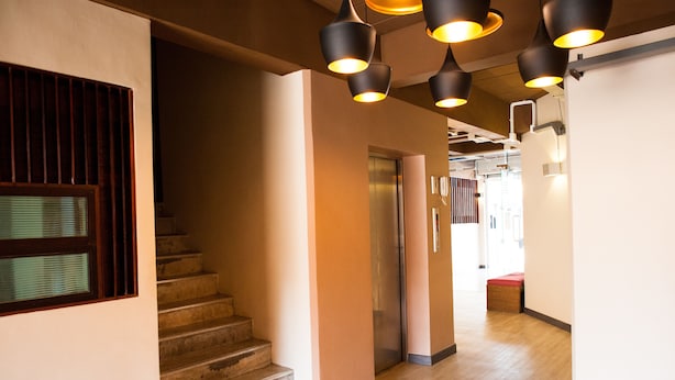 A modern interior with a staircase, an elevator, and pendant lighting. - KENCOZY accommodation (Bangkok)