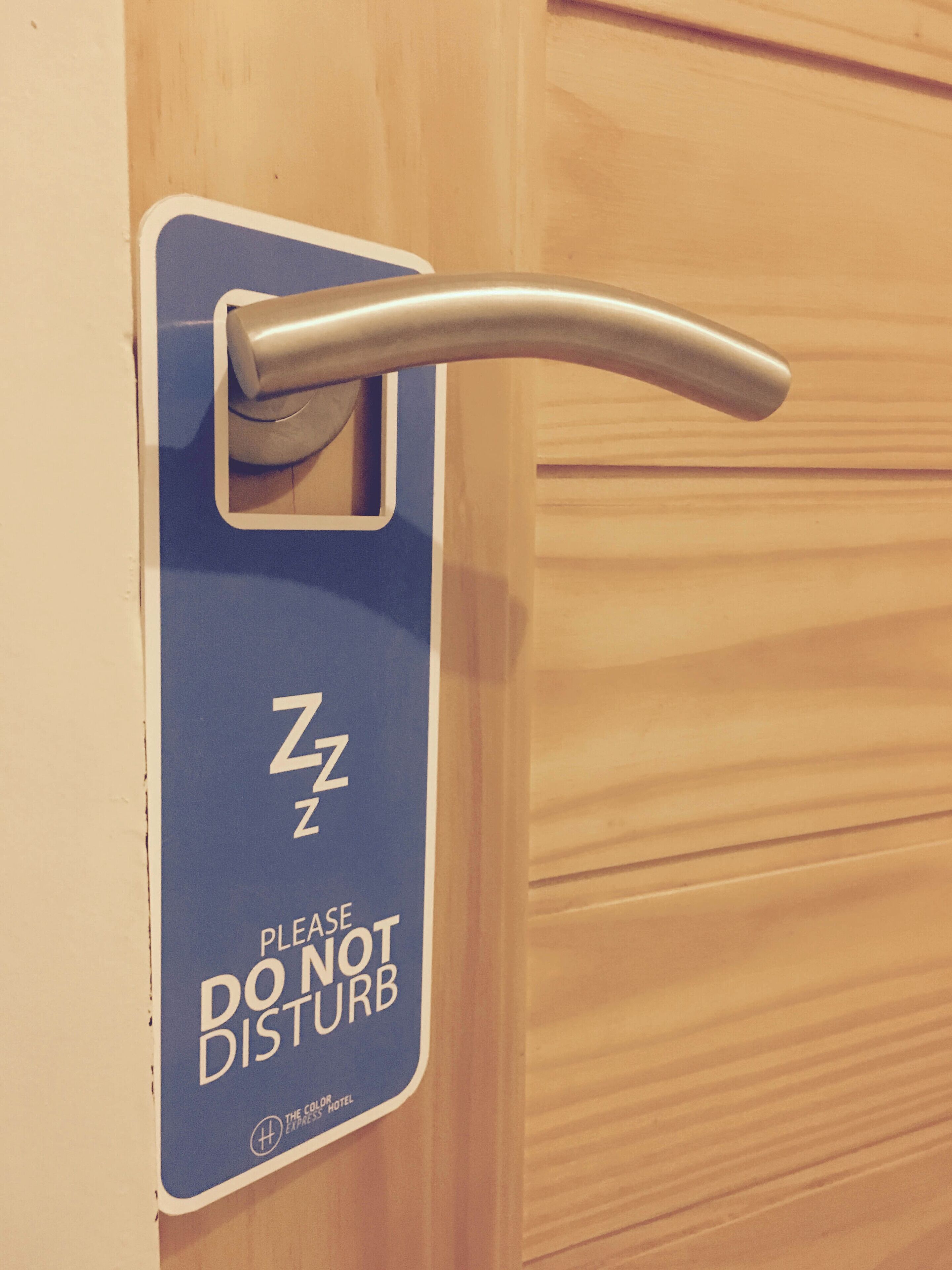 A blue sign with "PLEASE DO NOT DISTURB" and "Z Z" indicating the room is occupied.