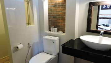 Ein Badezimmer mit Toilette, Waschbecken, Spiegel und Dusche.
