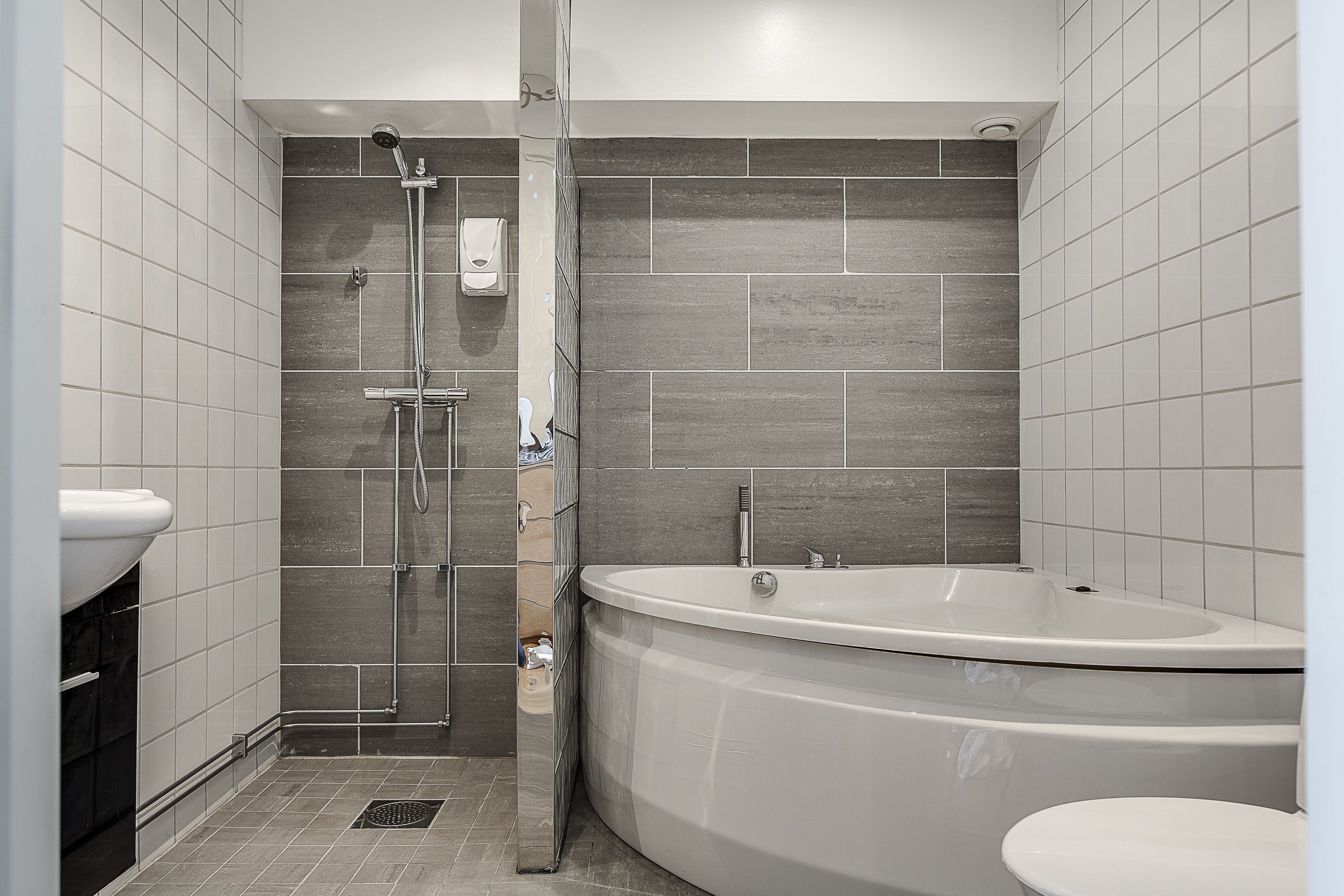 A modern bathroom with a shower, a bathtub, and a toilet.