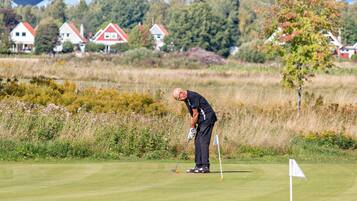 Golfers can tee off on the lush green course surrounded by residential homes and scenic vegetation.