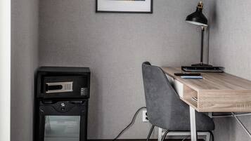 A compact office space with a desk, chair, and a black desk lamp.