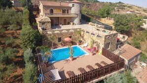 A villa with a swimming pool, stone walls, and a view of the surrounding landscape. - Il Castello (Piazza Armerina)