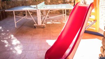 Relax and play in this outdoor space featuring a slide and ping pong table.