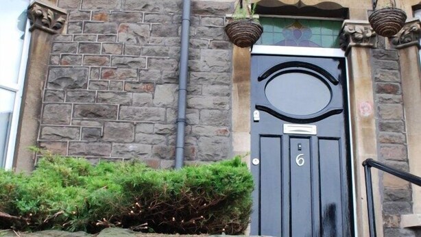 A stone building with a black door, number 6, and a small garden area in front. - Clift Guest House (Bristol)