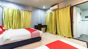A hotel room with a bed, a desk, and a shower area. - OYO 75304 Riverside Guesthouse (Takua Pa)