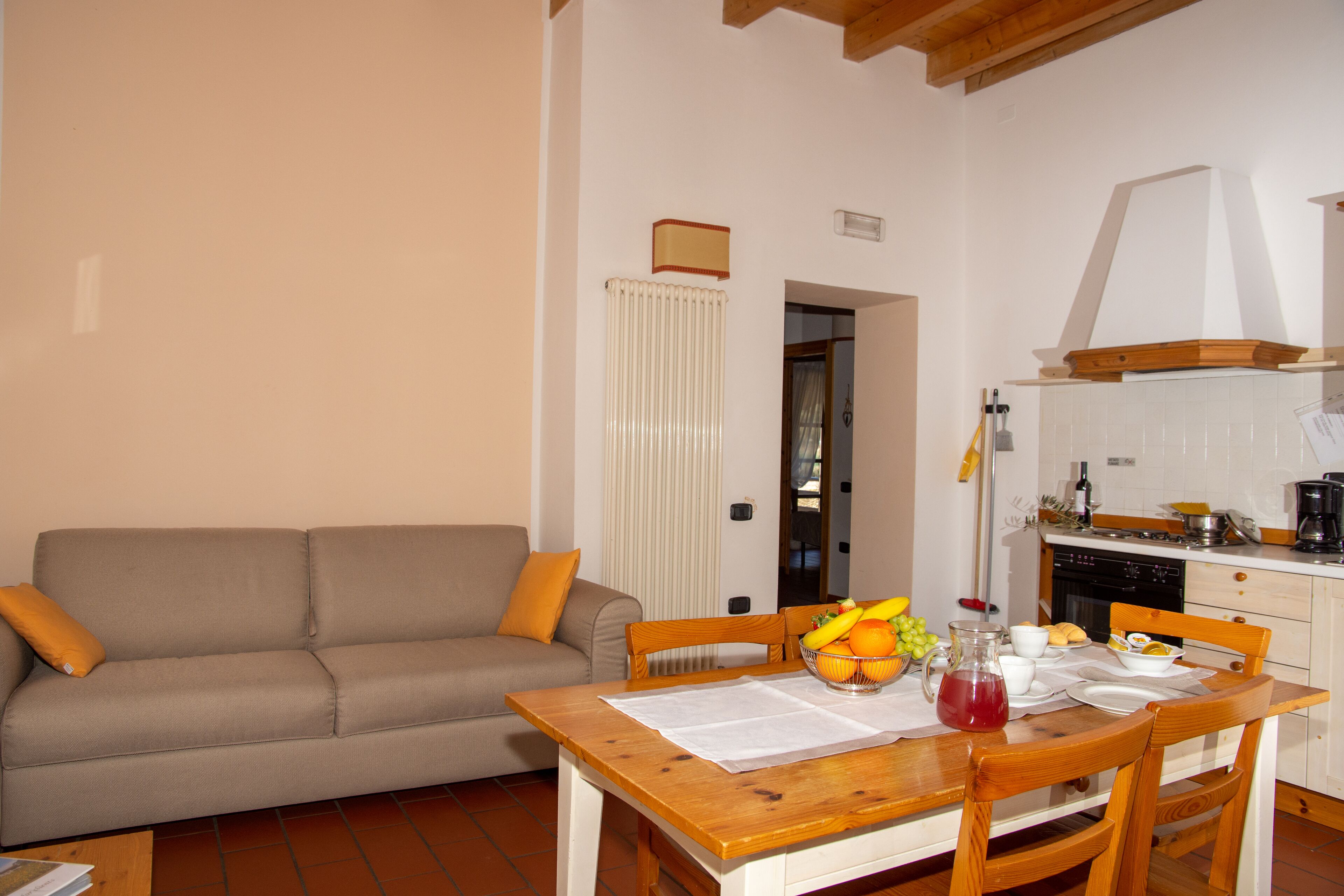 A cozy living room with a sofa and a dining table set for breakfast.