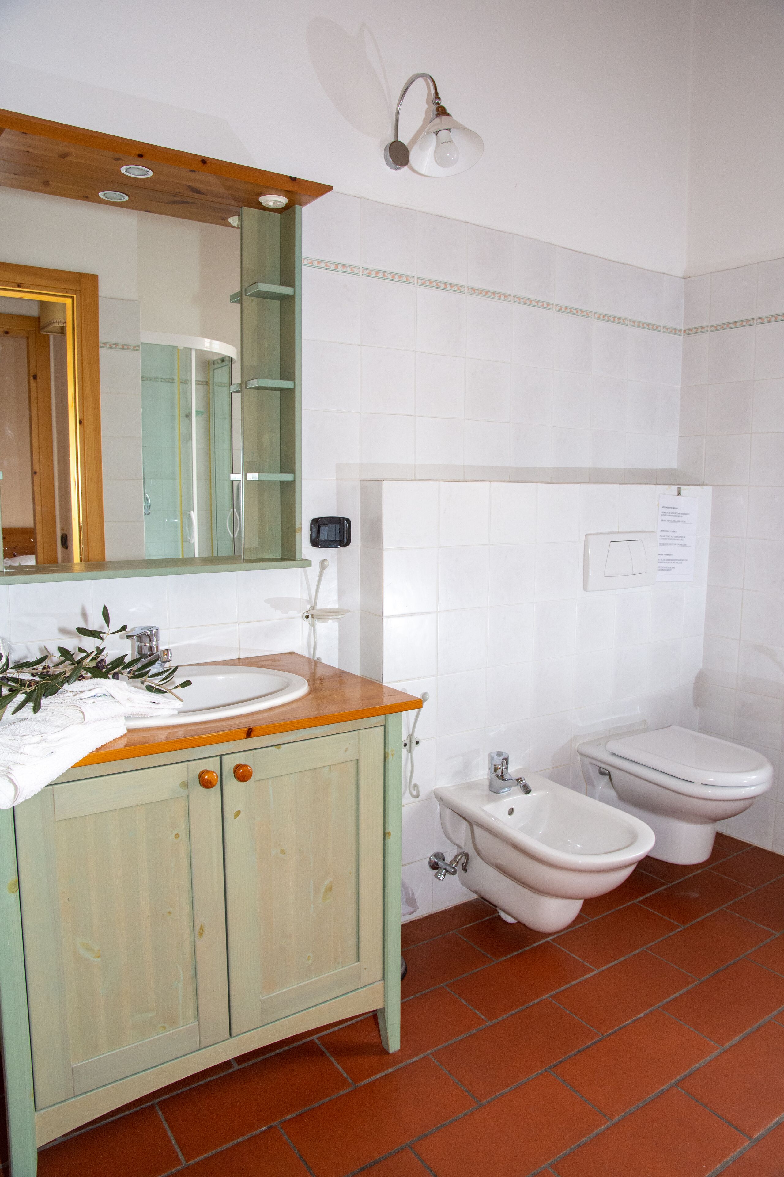 Une salle de bain avec un meuble-lavabo en bois, un lavabo, un bidet et des toilettes.