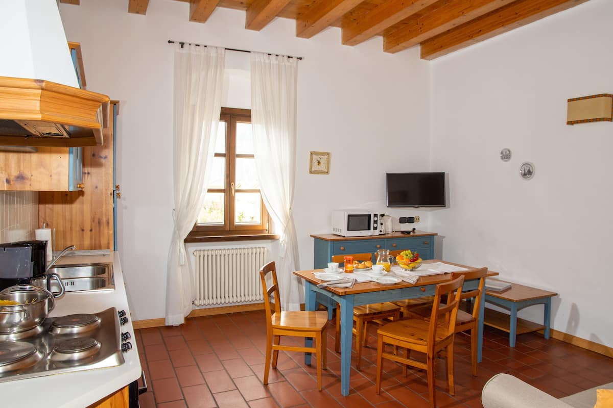 Une cuisine équipée d’une cuisinière, d’un four à micro-ondes et d’une table à manger avec des chaises.