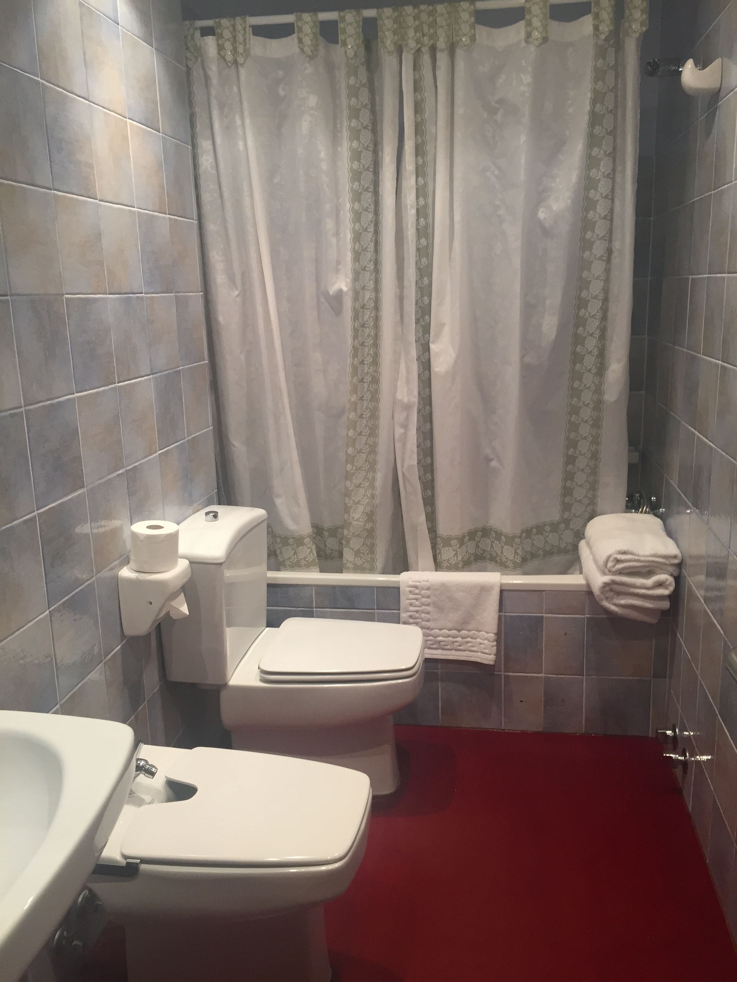 A bathroom with a toilet, bidet, and sink.