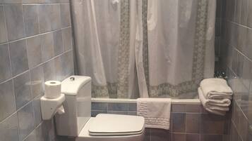 A bathroom with a toilet, bidet, and sink.