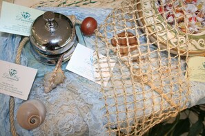 Een tafel met een net dat diverse voorwerpen bevat, zoals een schelp, een kaars en visitekaartjes.
