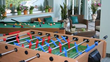 Relax and unwind in our spacious recreational area, featuring a foosball table, pool table, and comfortable seating.