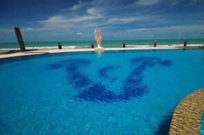 Una piscina al aire libre, sillones reclinables de piscina