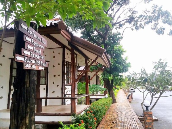 A building with a signpost indicating directions to the conference room, restaurant, beach, reception, and swimming pool. - Talkoo Beach Resort Khanom (Khanom)