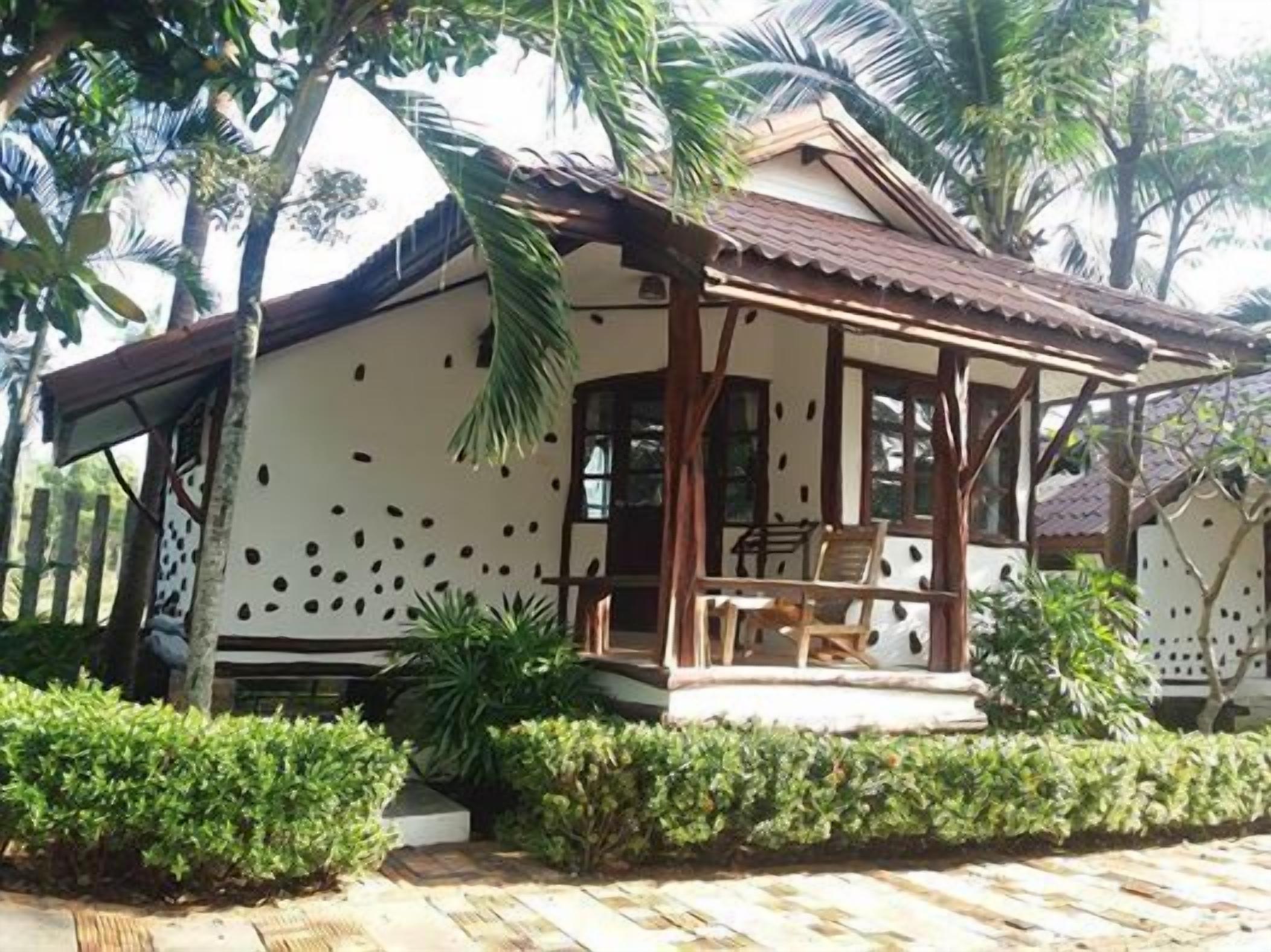 A small, single-story house with a tiled roof and a porch.