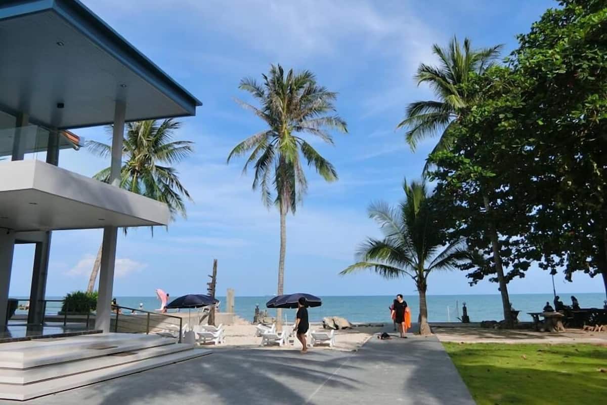 A modern building with a glass facade overlooking a beach.
