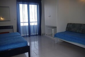 Una habitación con dos camas, un escritorio y un armario.