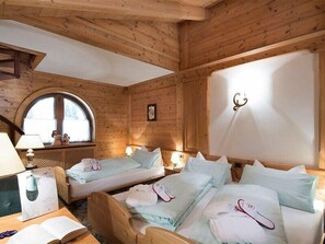 Habitación de cabaña de madera con dos camas, una ventana y un aplique de pared.
