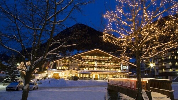 A hotel with a large building, multiple windows, and a snow-covered landscape.