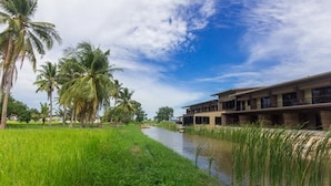 A riverside hotel with a modern design, featuring a long building with multiple balconies and a flat roof. - Cha-Am Country Home (Cha-am)