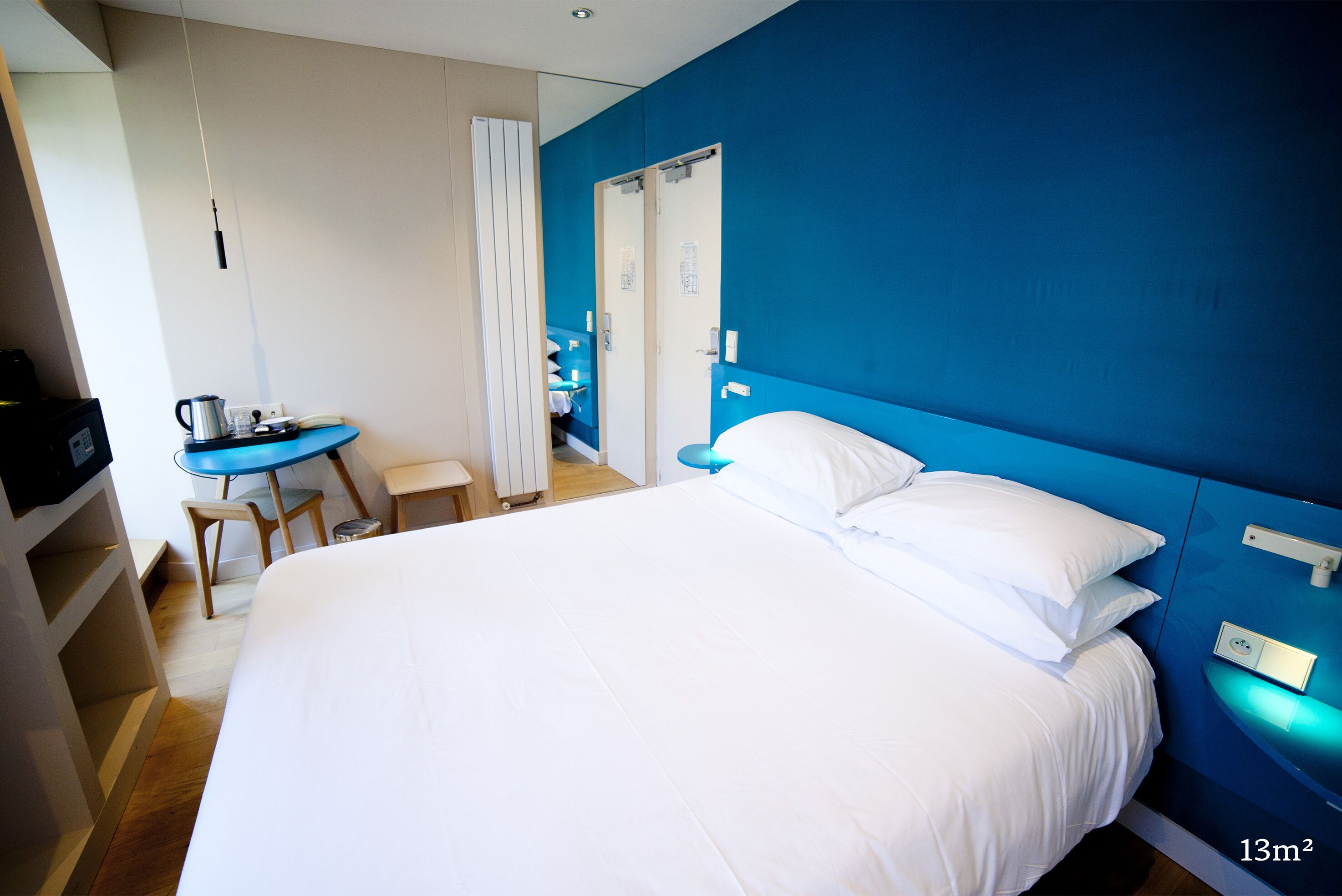 A hotel room with a large bed, a desk, and a chair.