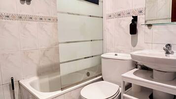 Un baño con bañera, inodoro y lavamanos.