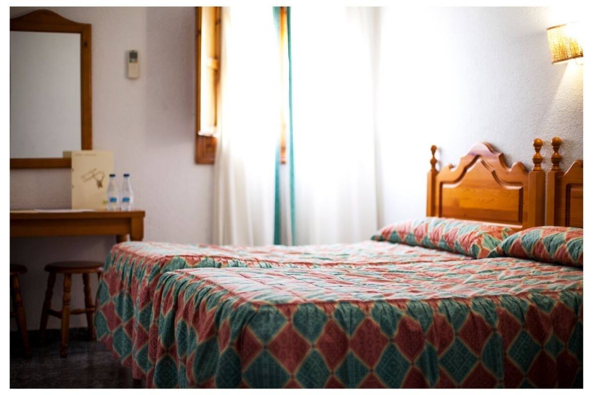 Une chambre d’hôtel avec un lit, un bureau et une chaise.