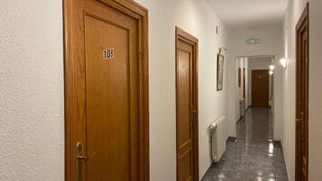 Un pasillo con puertas de madera, números 108 y 109, que dan a varias habitaciones.