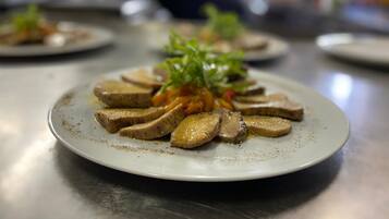 A plate of sliced mushrooms with a garnish of greens, served on a white plate.