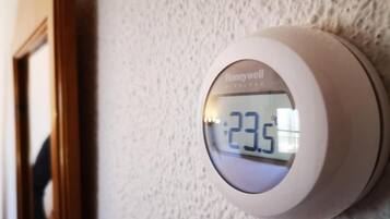 A Honeywell thermostat mounted on a textured wall.