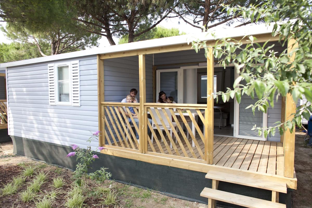 A small cabin with a wooden deck and a covered porch.