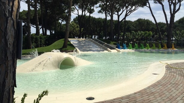 Ein Wasserpark mit Pool, Rutschen und einem Pflasterweg.