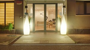 A building with a sign reading 'VERSALLES BERRI' and a large illuminated arrow pointing left. - Hotel Berri Versalles (Renteria)