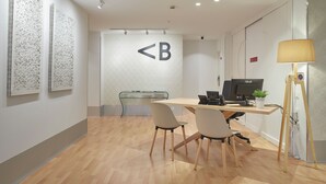 A modern office space with a glass partition, a desk with two chairs, an ASUS monitor, and a lamp. - Hotel Berri Versalles (Renteria)