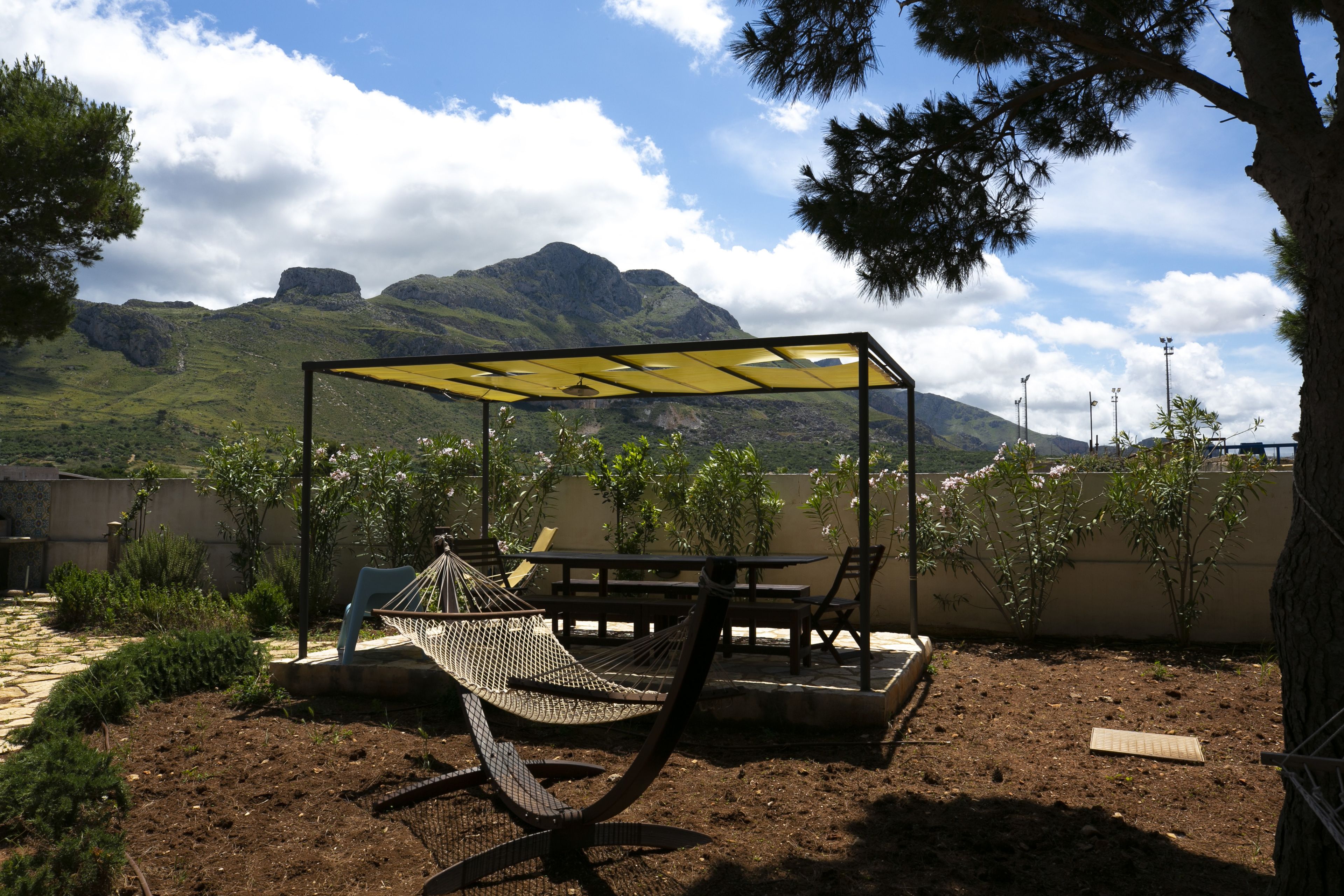 A hammock under a yellow canopy, a picnic table, and a view of mountains.