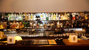 A bar with shelves of various liquor bottles and glasses. - Hotel Palm Beach (Pointe-Noire)